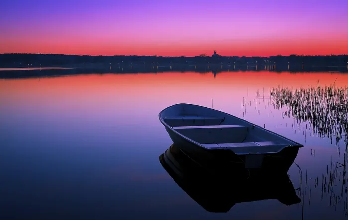 Framed Print : Boat in the background of the lake at a beautiful sunset