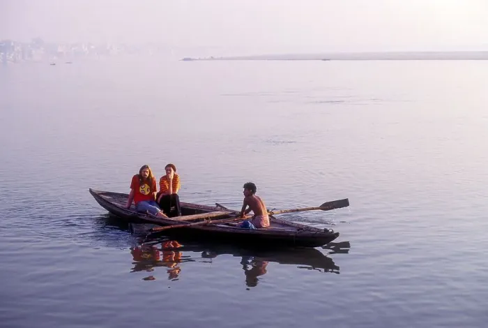 Framed Print : Boat man carrying tourists out to the centre of the River Ganga Ganges at Varanasi Benaras