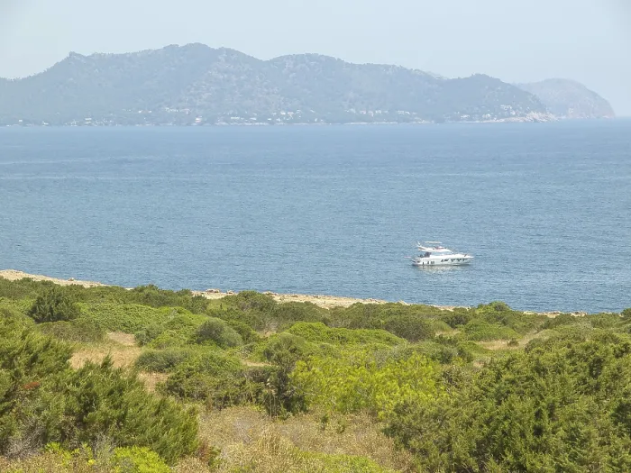 Framed Print : A boat on the sea with mountains and coast in the background
