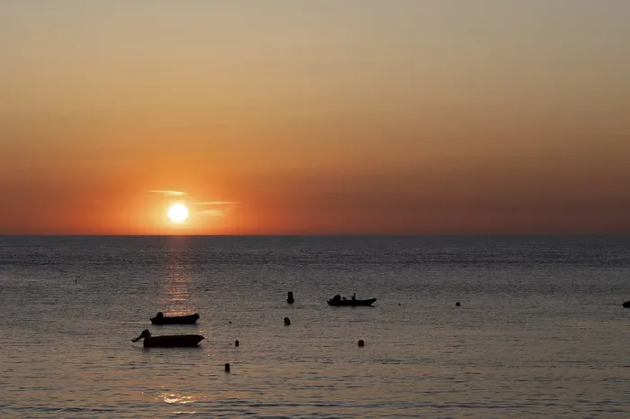 Framed Print : Boats in front of sunset at the sea