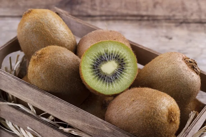 Framed Print : Box of fresh kiwi in on wooden background