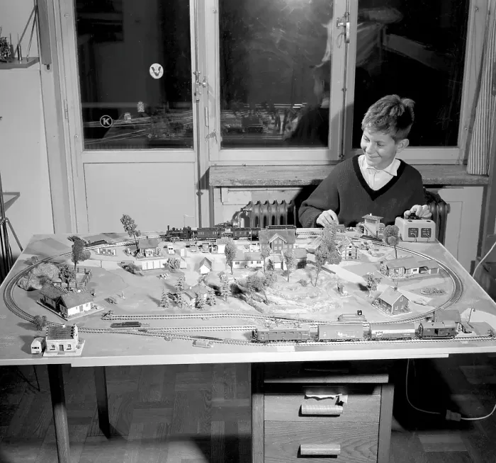 Framed Print : Boy in the 1950s. A boy at his model railroad mounted on a table in his room