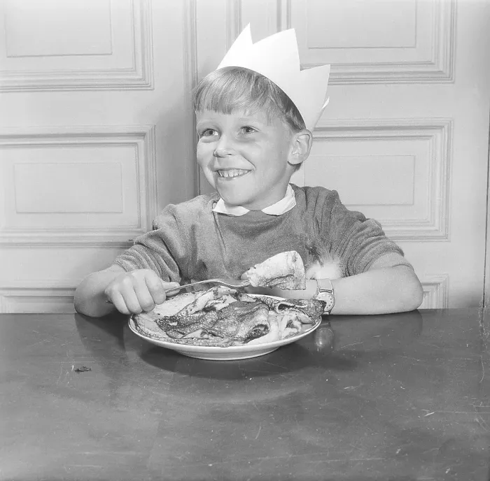 Framed Print : Boy in the 1950s. Smiling when sitting in front of a plate with pancakes and one on the fork, ready to eat. Sweden 1953 ref BL109-12