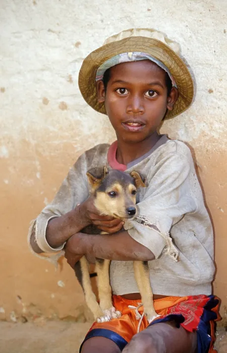 Framed Print : Boy with dog puppy on arm, Madagascar Framed Print : Boy with dog puppy on arm, Madagascar