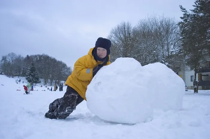 Framed Print : Boy rolling big snow ball