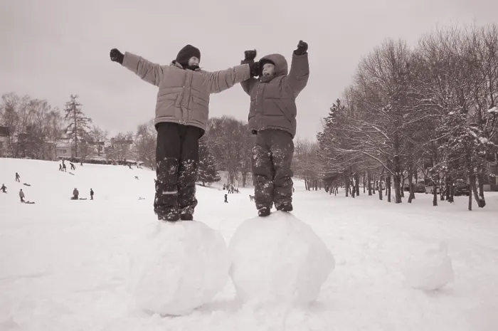Framed Print : Two boys standing on big snoww balls