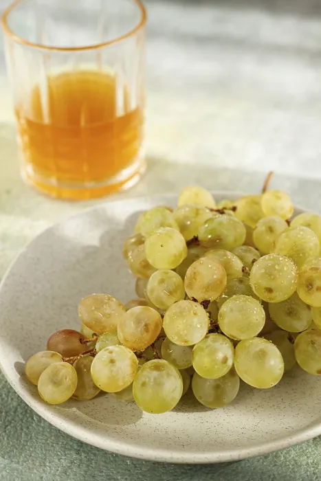 Framed Print : A branch of white grapes, on a gray plate Framed Print : A branch of white grapes, on a gray plate
