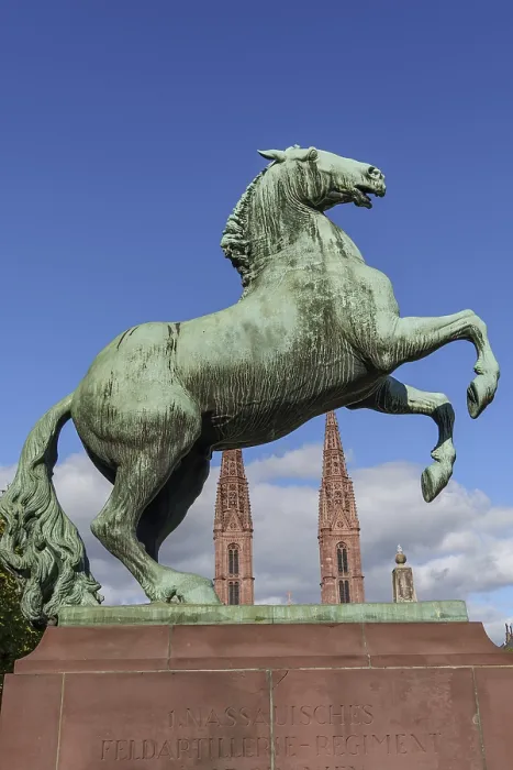 Framed Print : Bronze monument of a climbing horse in front of a neo-Gothic church Framed Print : Bronze monument of a climbing horse in front of a neo-Gothic church