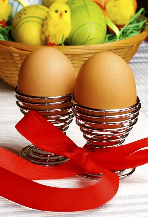 Framed Print : Brown eggs in metal holders with a red ribbon