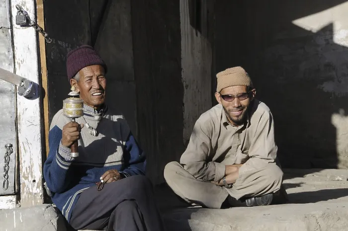 Framed Print : Buddhist Ladakhis with prayer wheel in front of a shop in Leh