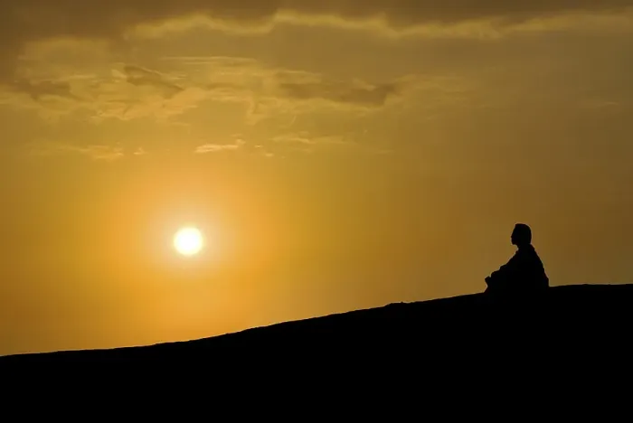 Framed Print : Buddhist meditating at sunset
