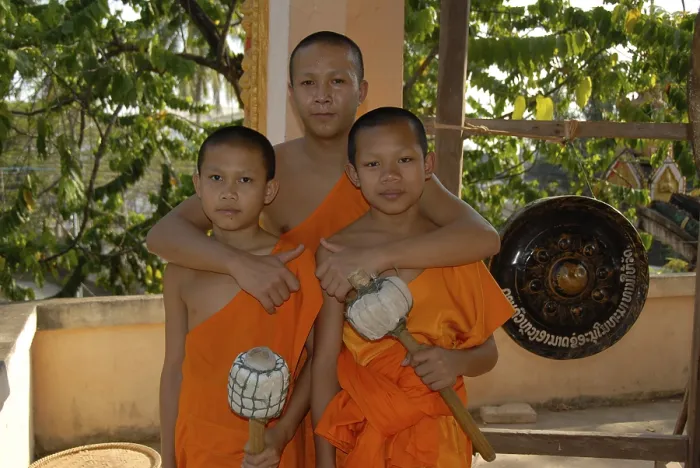 Framed Print : Buddhist monk embracing two novice monks