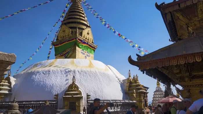 Framed Print : Buddhist stupa with prayer flags surrounded by visitors under a bright blue sky Framed Print : Buddhist stupa with prayer flags surrounded by visitors under a bright blue sky