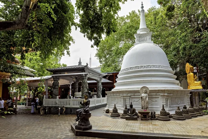 Framed Print : A Buddhist temple complex with a white stupa surrounded by Buddha statues and lush greenery