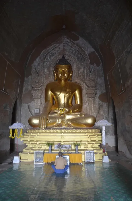 Framed Print : Burmese man sitting, praying in front of a golden Buddha statue