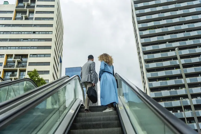 Framed Print : Business professionals ascending an outdoor escalator in a modern urban environment