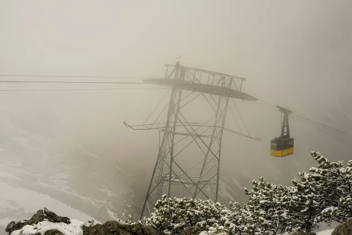Framed Print : Cable car technicians working in bad weather conditions