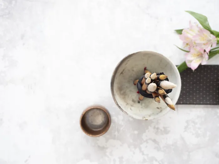Framed Print : Calligraphy brushes tied with black ribbon in ceramic bowl near inkstone and pink flowers