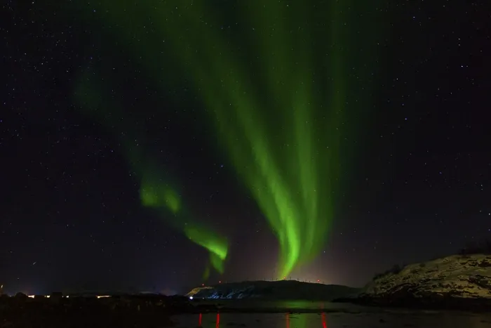 Framed Print : A calm scene where green auroras dance across the night sky reflected in water