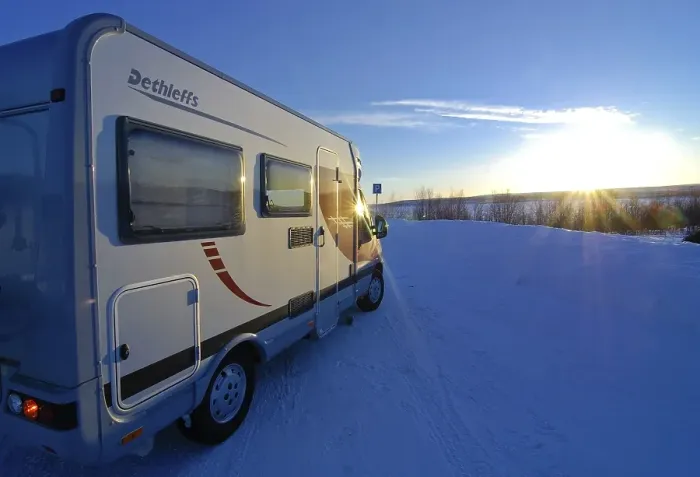Framed Print : Camper driving through wintry landscape at sunset