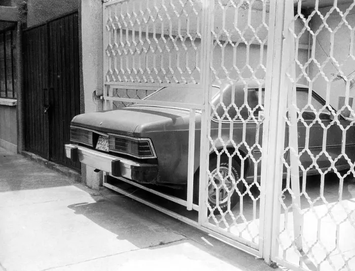 Framed Print : Car sticks out through fence, too small parking lot