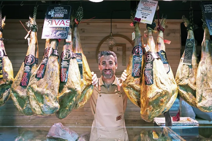 Framed Print : Castilian man, 40 years old, between Iberico hams for sale at the Mercado Central
