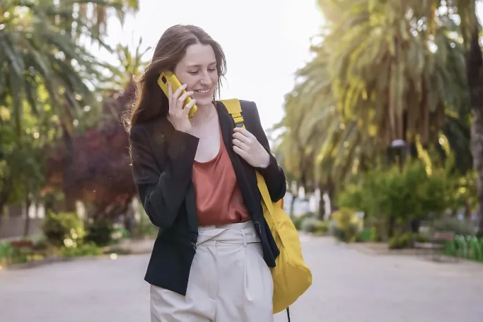 Framed Print : Casual woman with a yellow bag talking to the mobile phone outdoors