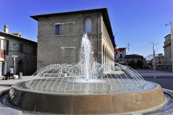 Framed Print : A central fountain bubbles in front of an Italian building in a sunny square
