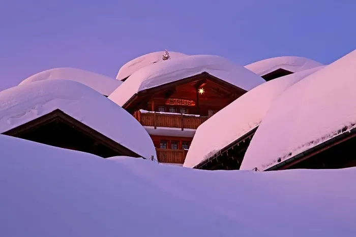 Framed Print : Chalets with deep snow in the village at dusk