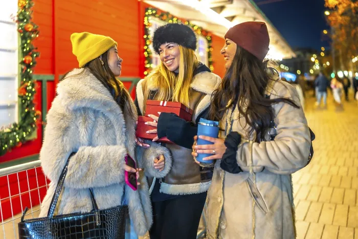 Framed Print : Three cheerful women holding christmas gifts and hot drinks