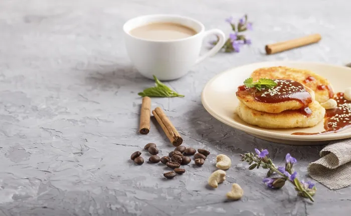 Framed Print : Cheese pancakes with caramel sauce on a beige ceramic plate and a cup of coffee on a gray concrete background