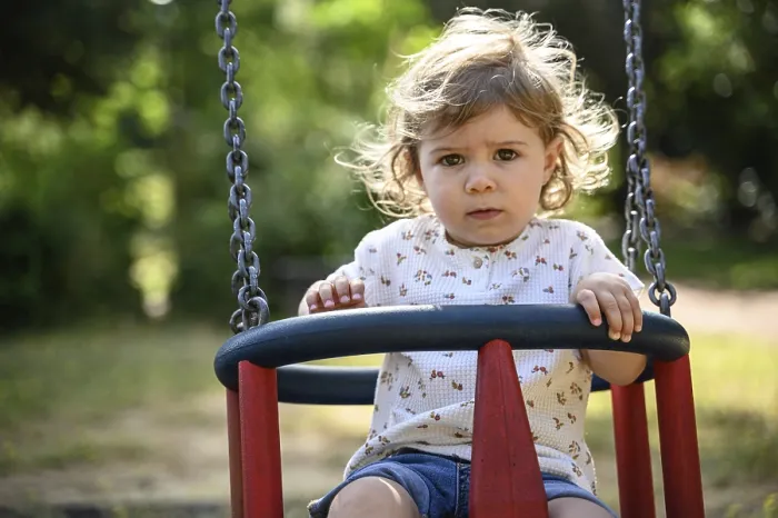 Framed Print : Child, 2 years, swings outdoors in a playground with a sunny atmosphere
