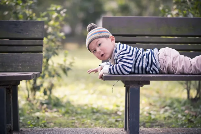 Framed Print : Child lying on a bench in the park