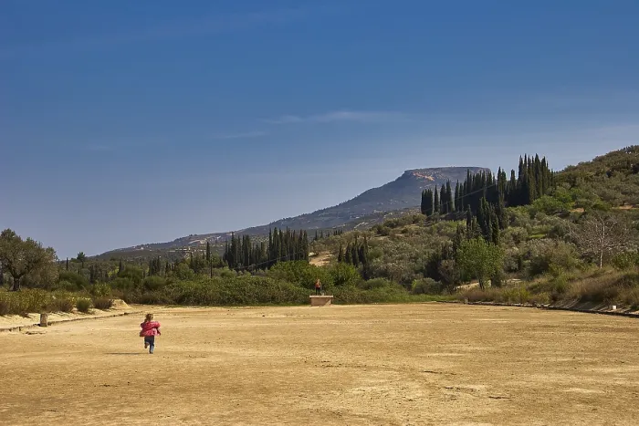Framed Print : A child runs across a dry meadow to distant mountains Framed Print : A child runs across a dry meadow to distant mountains