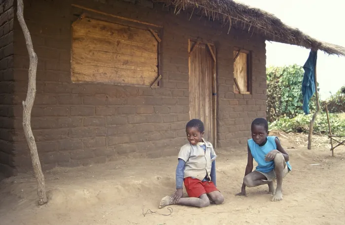 Framed Print : Children in front of a clay hut on the side of the road