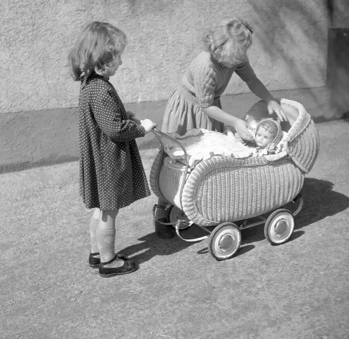 Framed Print : Two children play with a doll in a pram