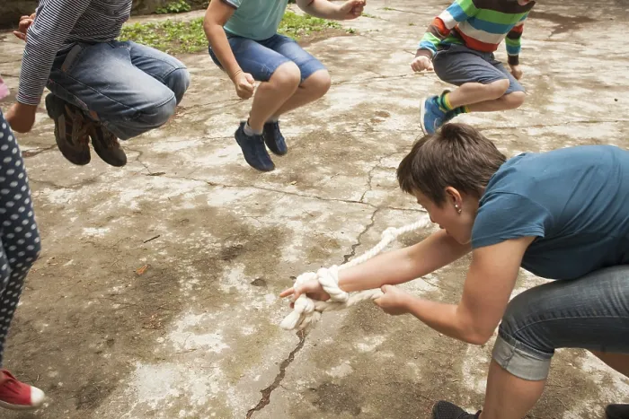 Framed Print : Children play outdoors jumping over the rope