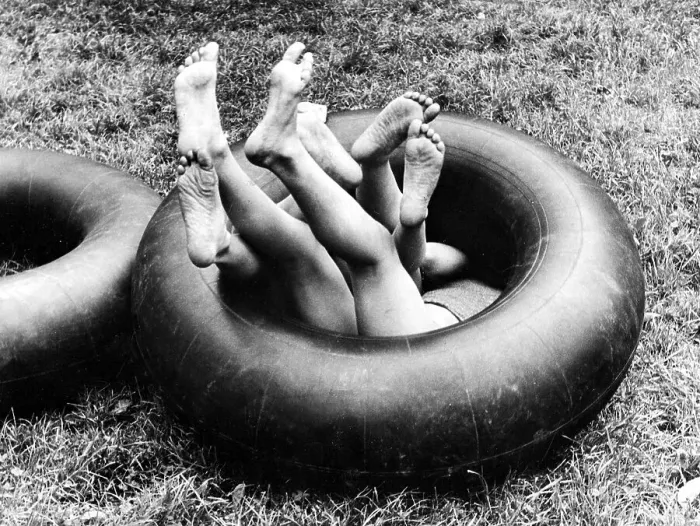 Framed Print : Three children playing in one innertube ca