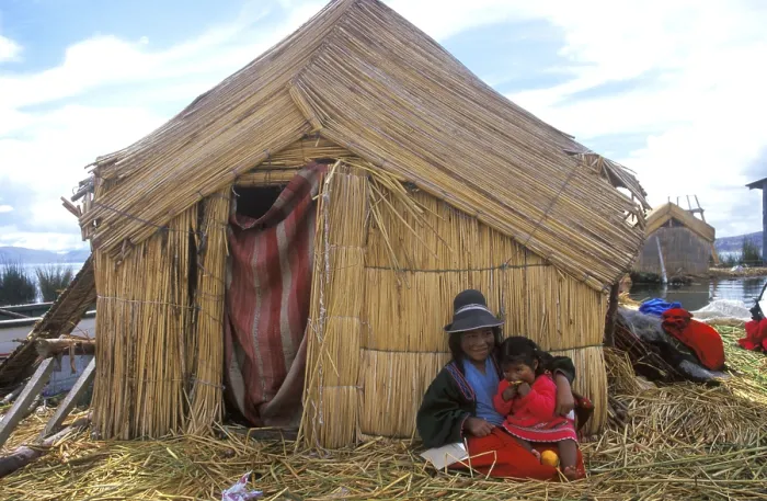 Framed Print : Children sitting in front of a reed hut on a floating Uro island in Lake Titcaca