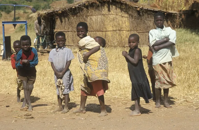 Framed Print : Children in front of a straw hut on the side of the road Framed Print : Children in front of a straw hut on the side of the road