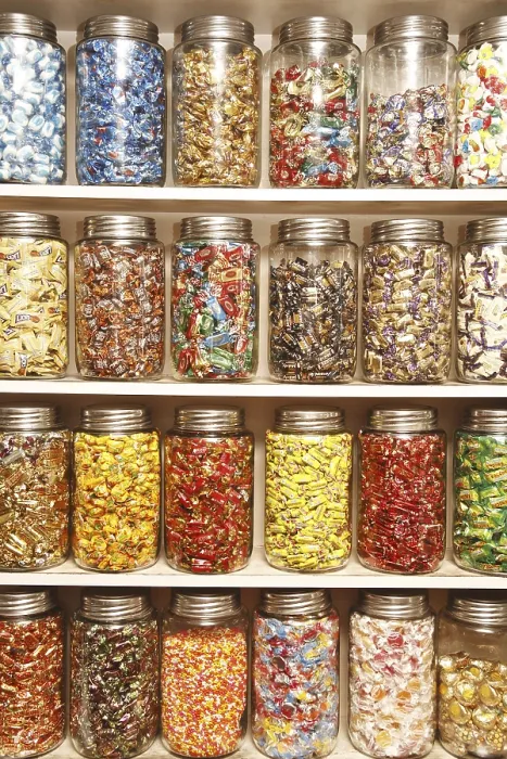 Framed Print : Chocolates kept in different glass jars on selves in shop