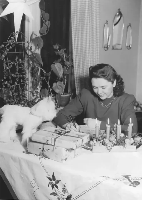 Framed Print : Christmas in the 1940s. A woman is wrapping christmas gifts