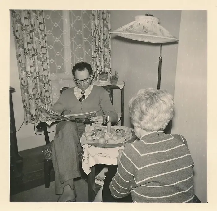 Framed Print : Christmas 1956: A married couple sits at a small table with a candle and Christmas biscuits on top