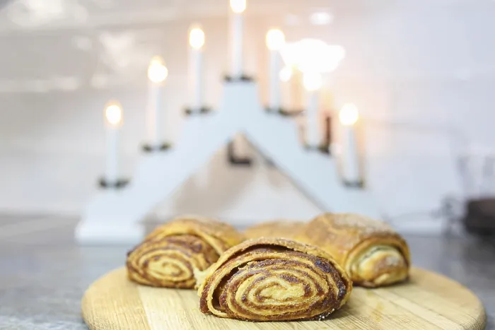 Framed Print : Cinnamon rolls on a wooden board with gentle light from decorative candles