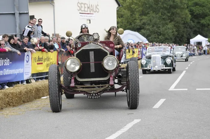 Framed Print : A classic car races in front of spectators on the street