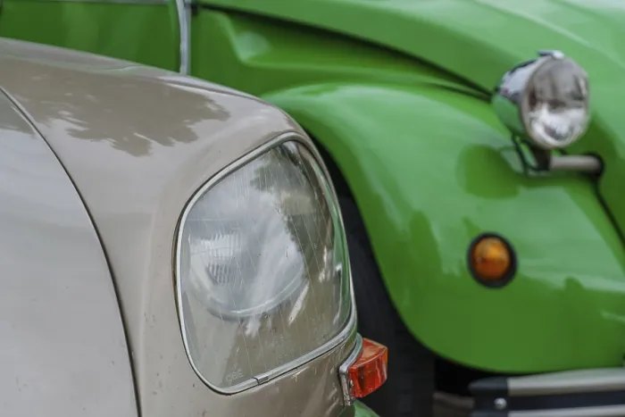 Framed Print : Two classic cars in green and beige with striking headlights