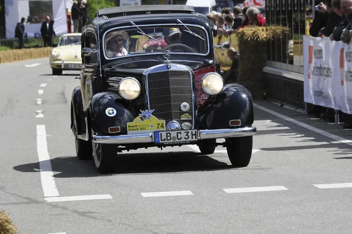Framed Print : A classic Mercedes vintage car drives past spectators at a sunny road race