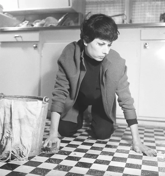 Framed Print : Cleaning in the 50s. A woman washes the floor with a scrub brush