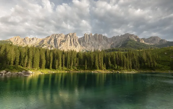 Framed Print : A clear lake (lake Carezza) reflects a dense spruce forest (Picea abies) and majestic mountains under a cloudy sky Framed Print : A clear lake (lake Carezza) reflects a dense spruce forest (Picea abies) and majestic mountains under a cloudy sky