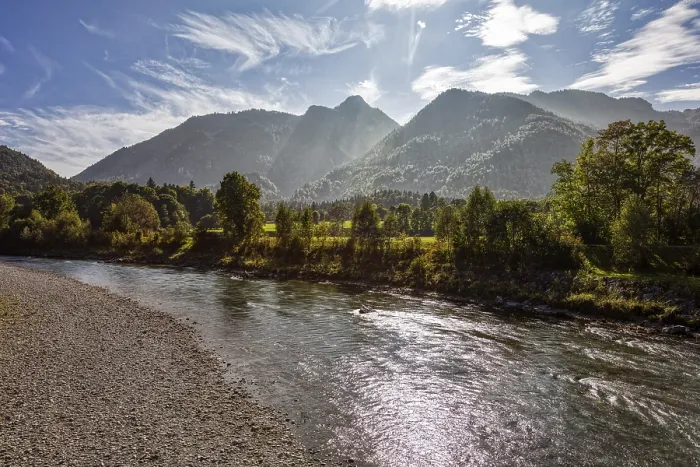 Framed Print : A clear river flows through an open landscape with a mountain in the background
